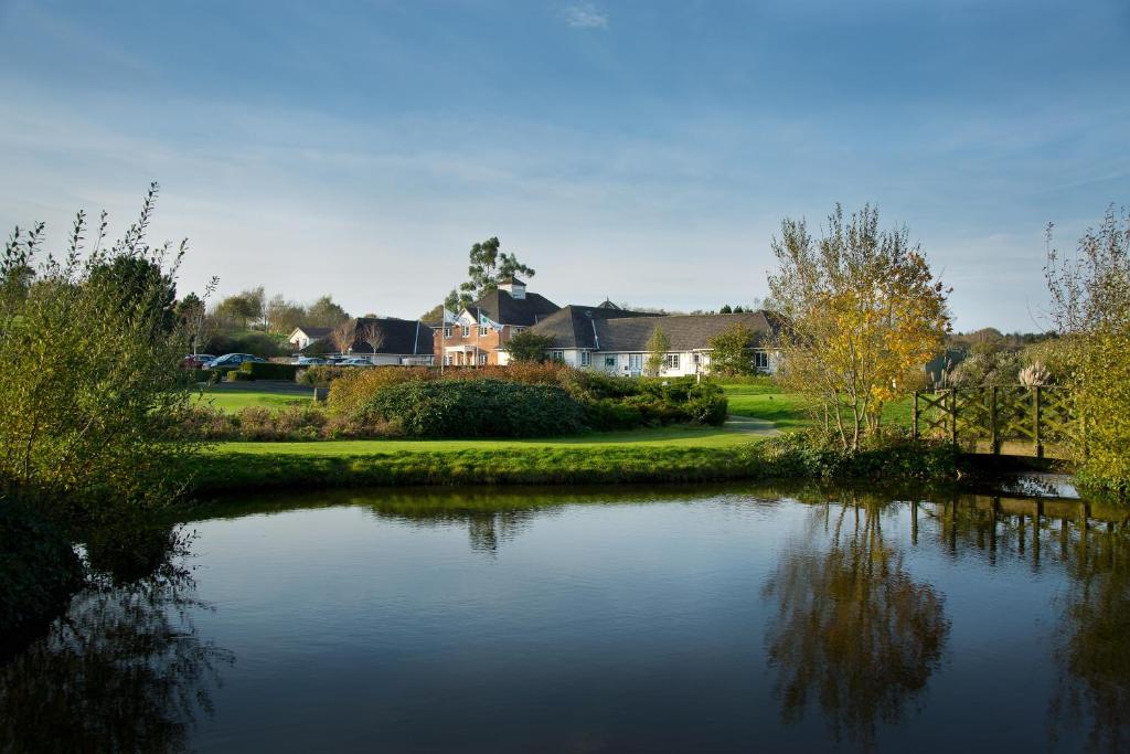 金斯克利尔桑福德温泉酒店及高尔夫俱乐部的享有池塘的景色,池塘的背景是房子