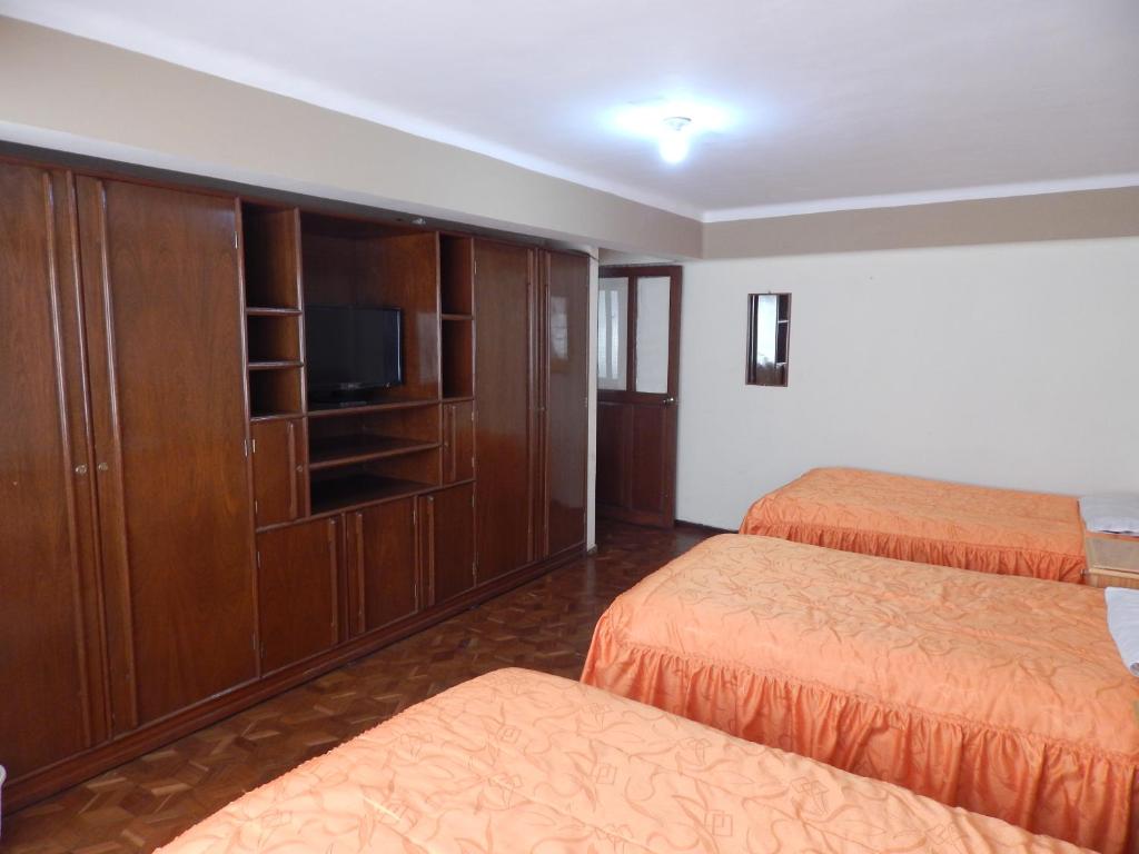 苏克雷Casa de Huespedes Isabella的一间酒店客房,设有两张床和电视