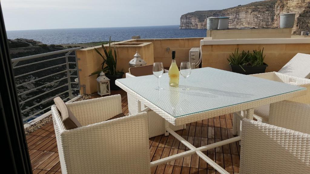 克伦蒂Kantra Residence的阳台上配有白色的桌椅,享有海景