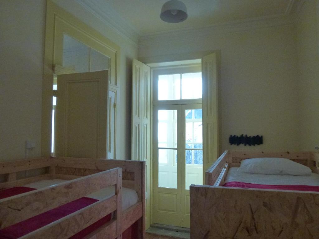 波尔图卡瓦爱特丽尔旅舍的一间卧室设有两张床、一个浴缸和一个窗口。