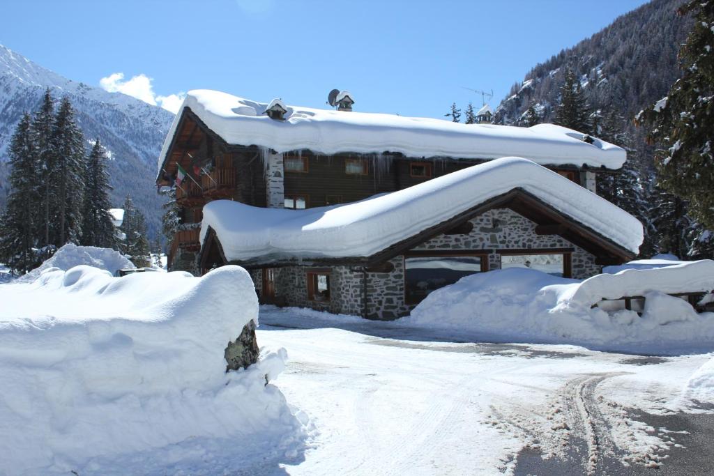 尚波吕克培缇图娜琳酒店的雪覆盖的小屋,有一堆积雪