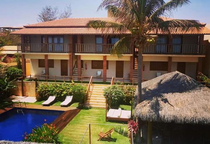 卡诺格布拉达Pousada Dona Flor的棕榈树和游泳池的房子
