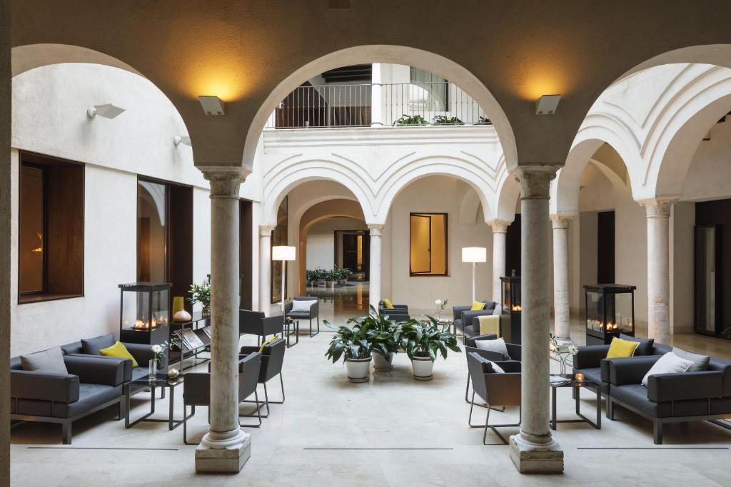 塞维利亚卢赛罗波萨达酒店的大楼内带桌椅的大堂