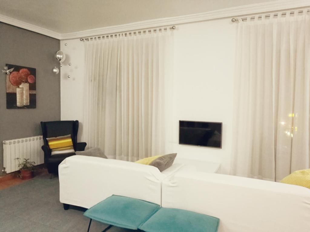 马德里特拉安旅馆的客厅配有白色的沙发和椅子