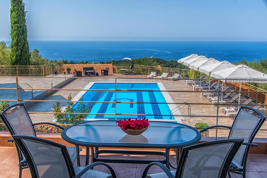 阿约斯尼奇塔斯Eltheo Villas的一个带游泳池的庭院里的桌椅