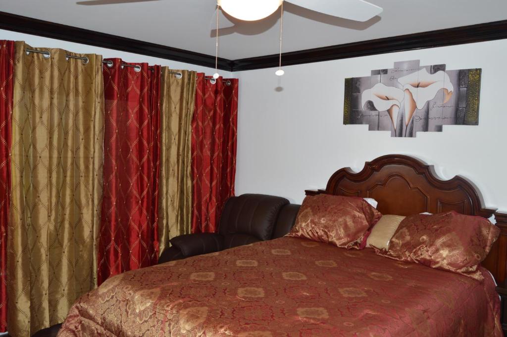 自由港市Lakeview Studio Apartments On Golf Course的一间卧室配有一张带窗帘的床和吊扇