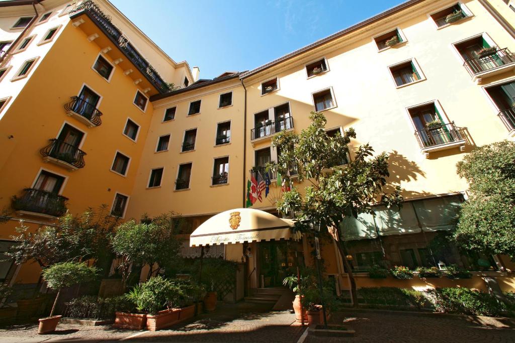 帕多瓦Majestic Toscanelli (centro storico)的一座黄色的大建筑,前面有一棵树