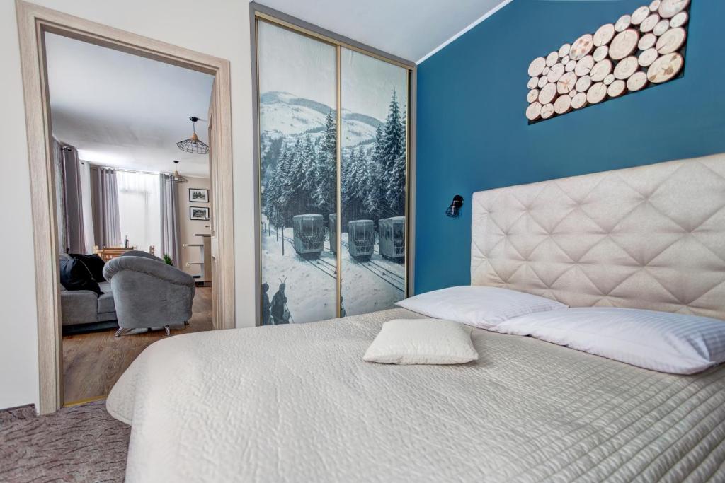 克雷尼察Apartamenty Parkowa的卧室配有白色的床和蓝色的墙壁