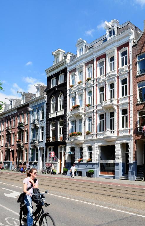 阿姆斯特丹博物馆巷酒店的骑着自行车沿着城市街道的女人