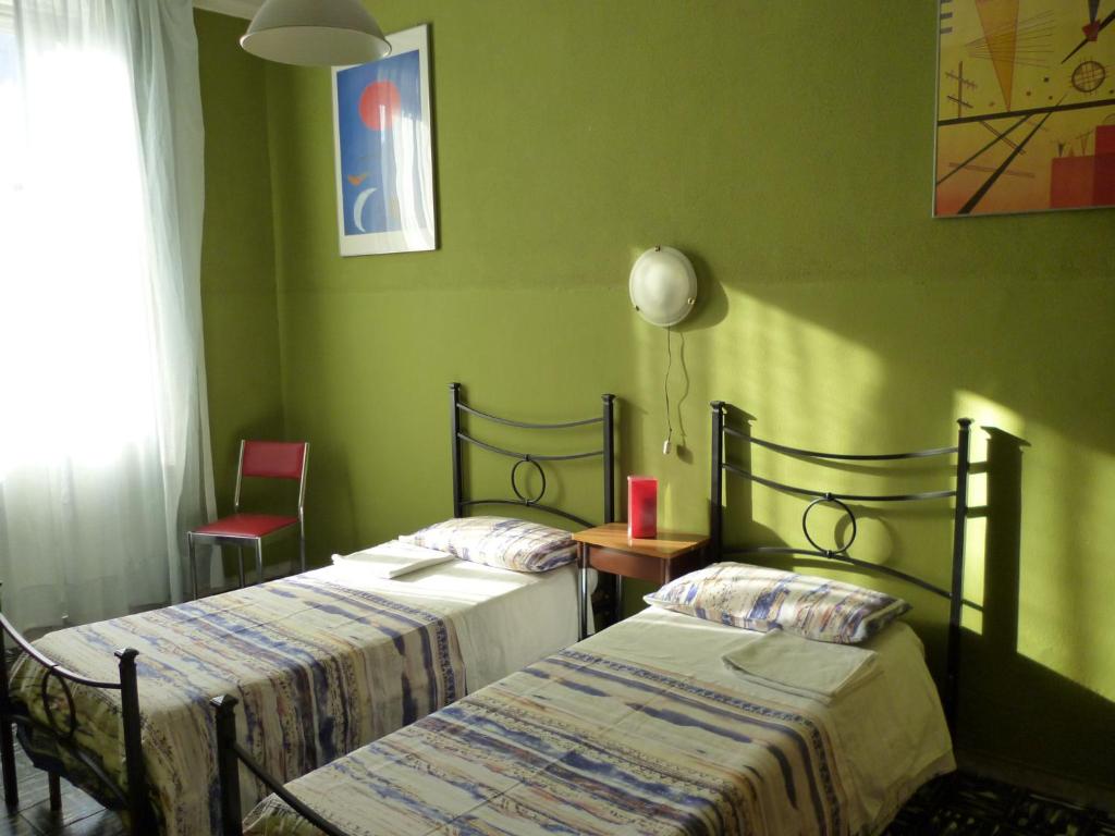 罗马Hotel Giamaica for Girls & Ladies Only的绿墙客房内的两张床