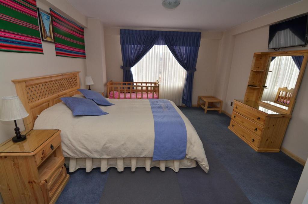 拉巴斯阿尔穆德纳公寓酒店的一间卧室配有一张带蓝色枕头的大床