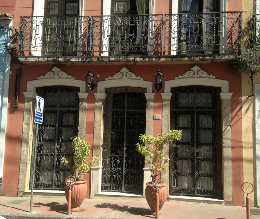 萨尔瓦多索尔卡尔穆套房公寓的一座带黑色门和阳台的建筑