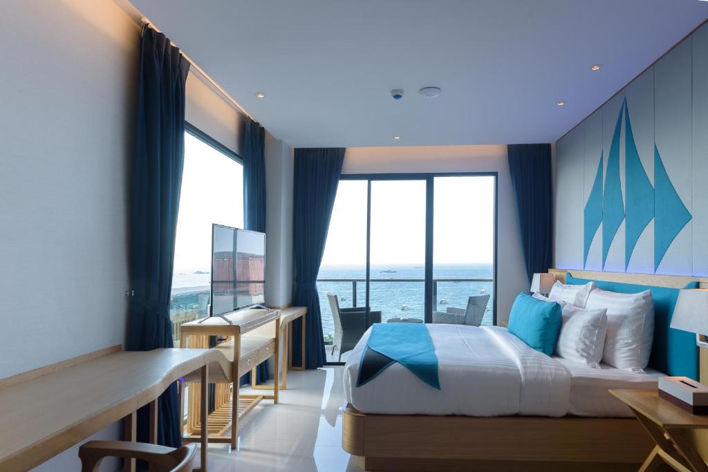 芭堤雅市中心Z10深蓝酒店的酒店客房设有一张床、一张书桌和窗户。