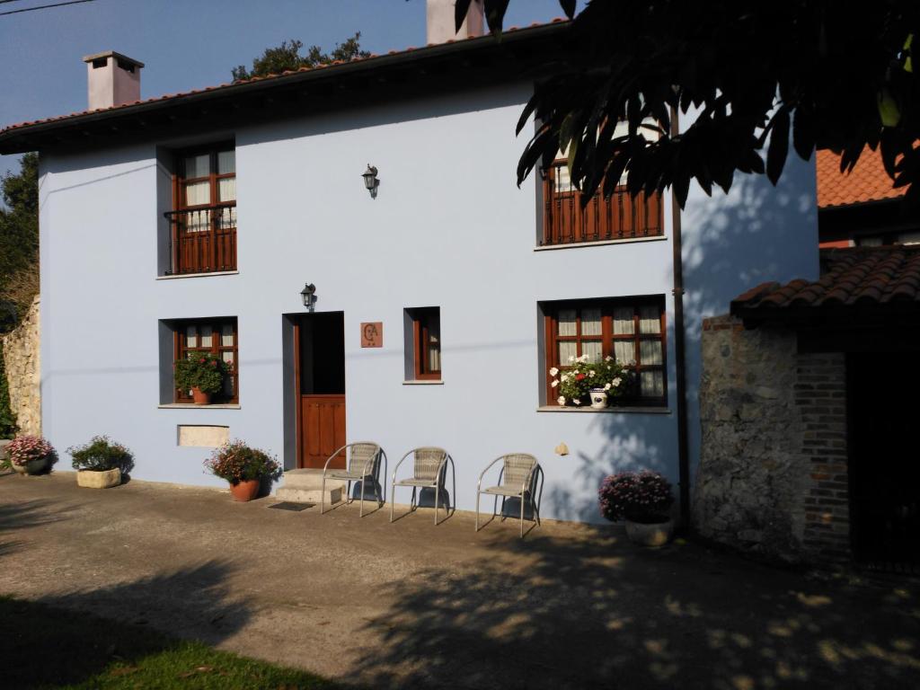 VillahormesCasa Rural Casa Azul的前面有椅子的白色房子