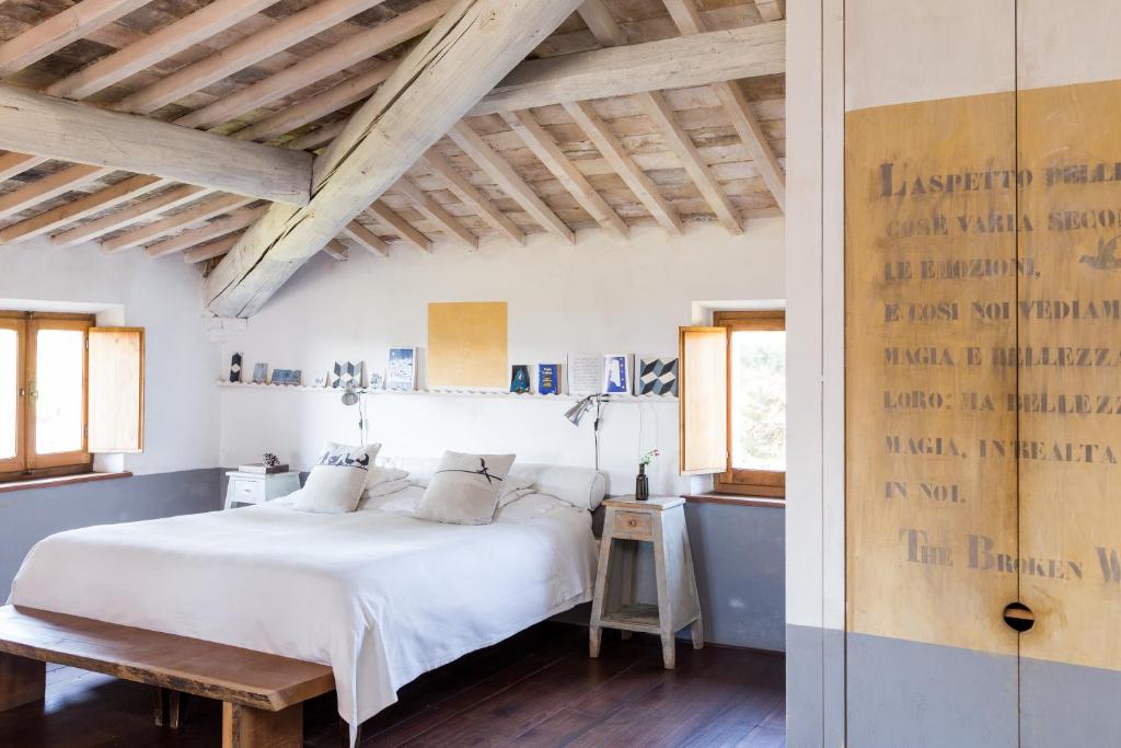 蒙特普齐亚诺圣马蒂诺农家乐的卧室设有白色的床和木制天花板。