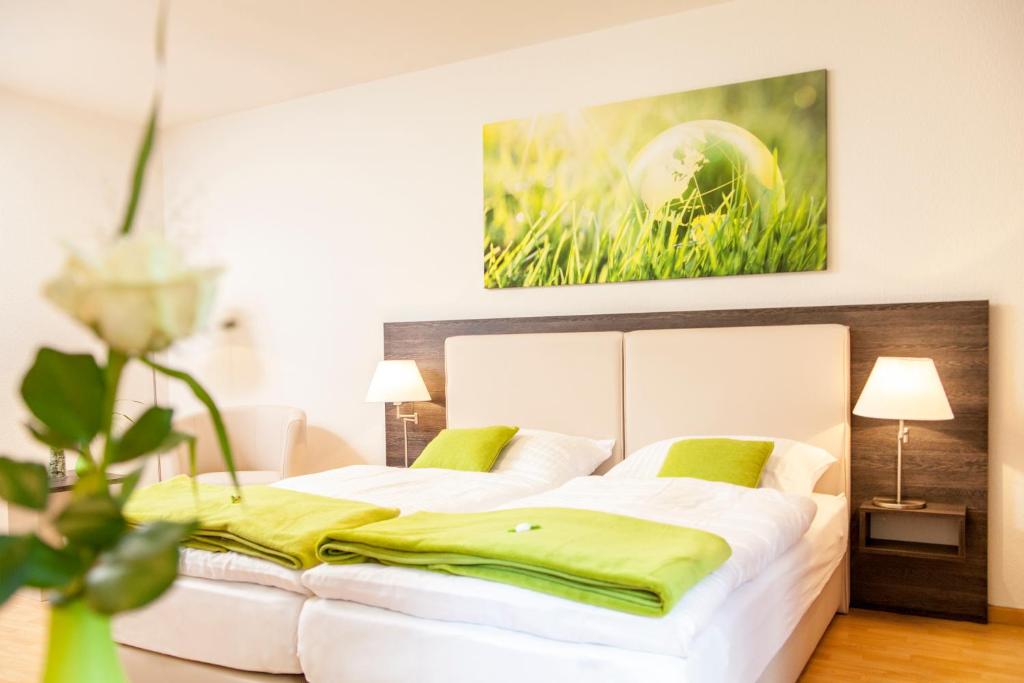 汉诺威艾林瑞德斯提福特公寓酒店的卧室配有带绿色枕头的大型白色床