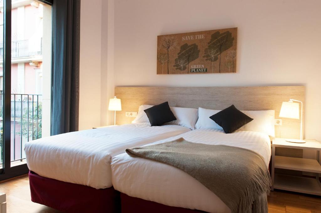 巴塞罗那MH格拉西亚公寓的一间卧室设有一张大床和一个大窗户