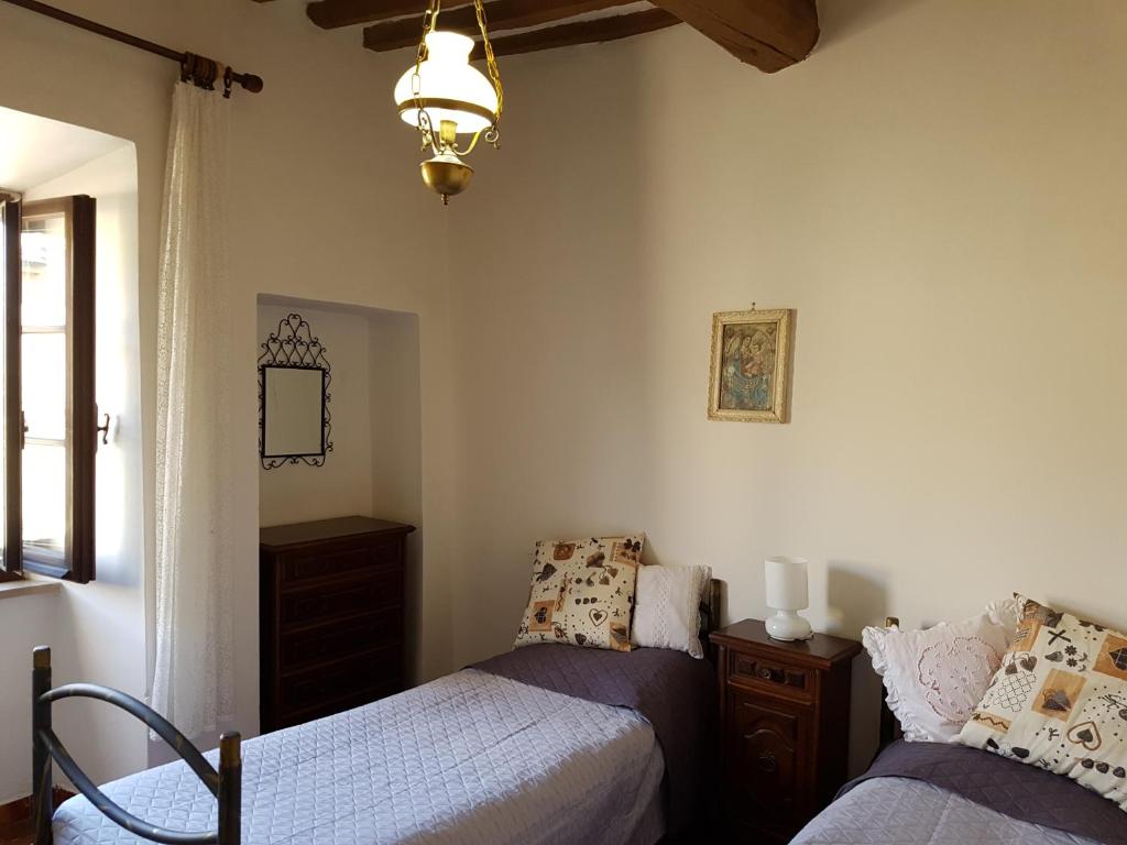 卡斯蒂戈隆·多尔希亚Le Pietre Antiche的一间卧室配有两张床和吊灯。