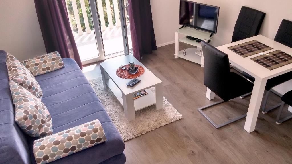 蒂瓦特Apartments Mila Tivat的客厅配有蓝色的沙发和桌子