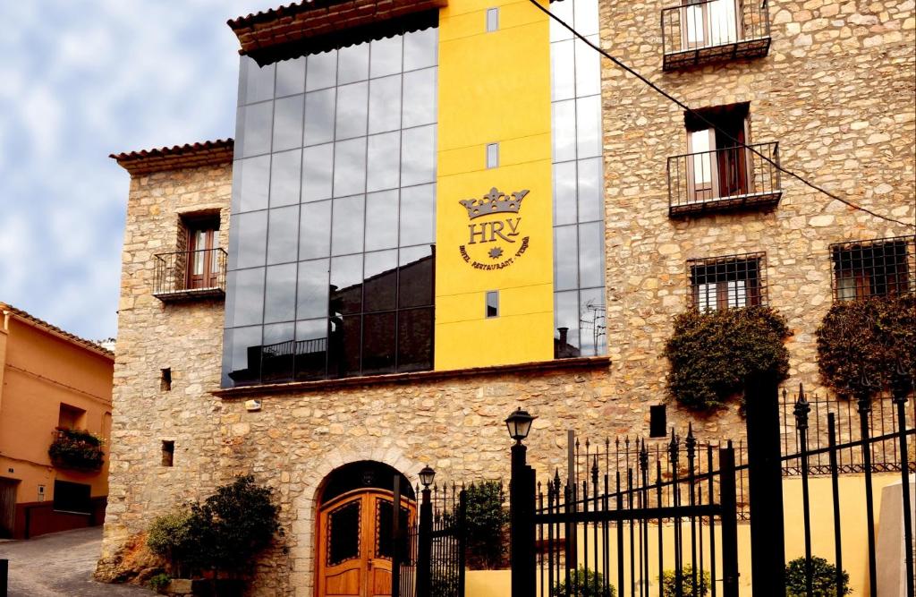 Sueras贝尔迪亚餐厅酒店的黄色的建筑,旁边是钟