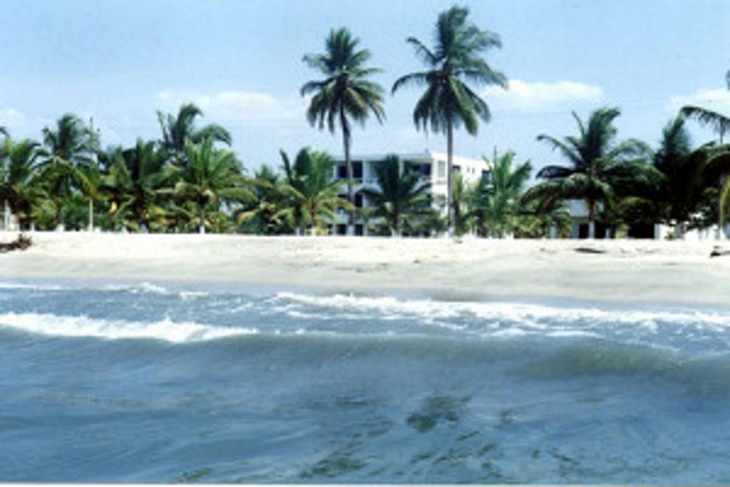 科韦尼亚斯Apartamentos Las Múcuras的棕榈树海滩,房子和大海