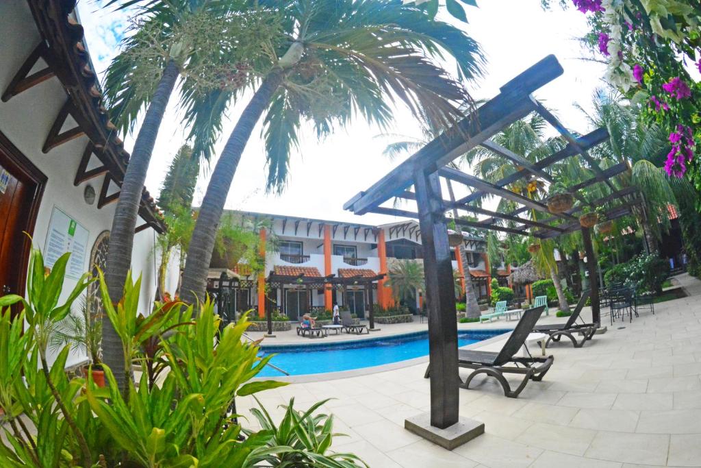 马那瓜欧罗裴傲酒店 的一个带游泳池和棕榈树的度假村