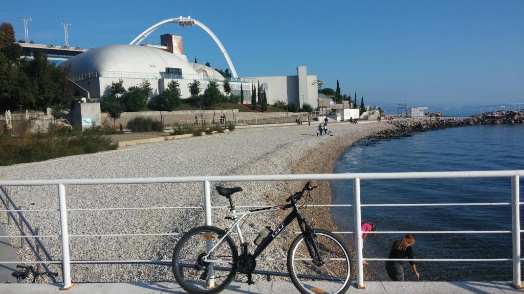 里耶卡Apartment Serpa的停在水边的围栏上的自行车