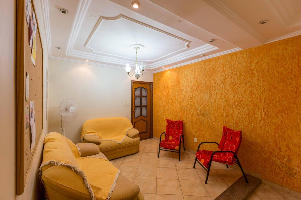 坎皮纳斯Pousada F7的客厅设有黄色墙壁和红色椅子