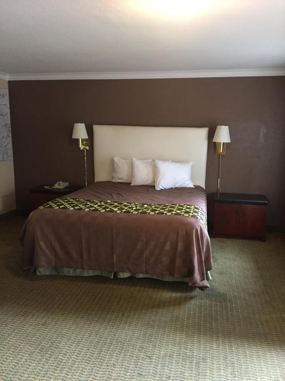 斯托克顿斯托克顿美国汽车旅馆的一张大床,位于酒店带两盏灯的房间
