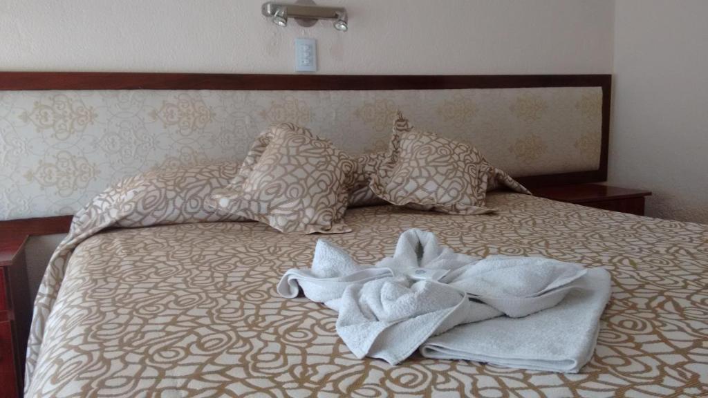米拉玛Hotel Neptuno的一张带毛巾和枕头的床