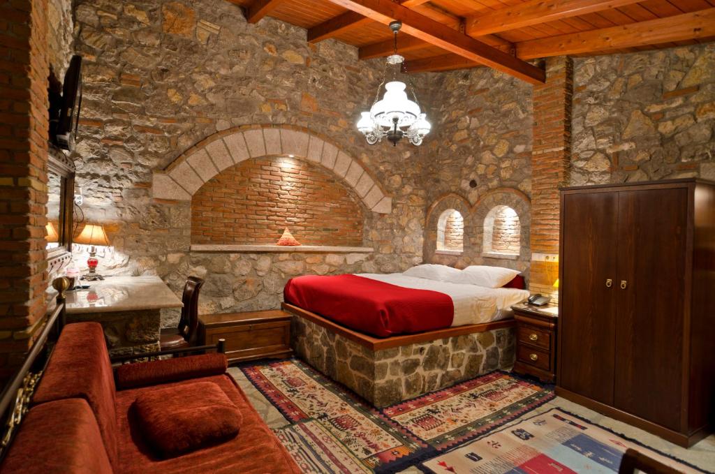 纳夫普利翁玛丽安娜酒店的一间卧室设有一张床和石墙