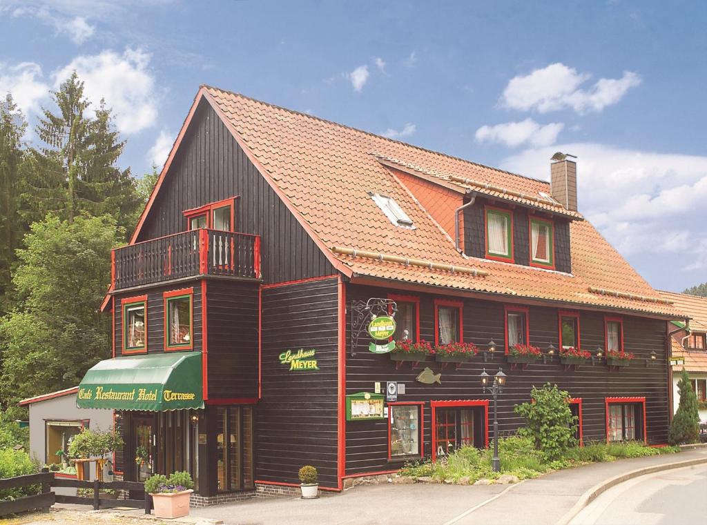 RiefensbeekLandhaus Meyer的黑色建筑,有红色屋顶