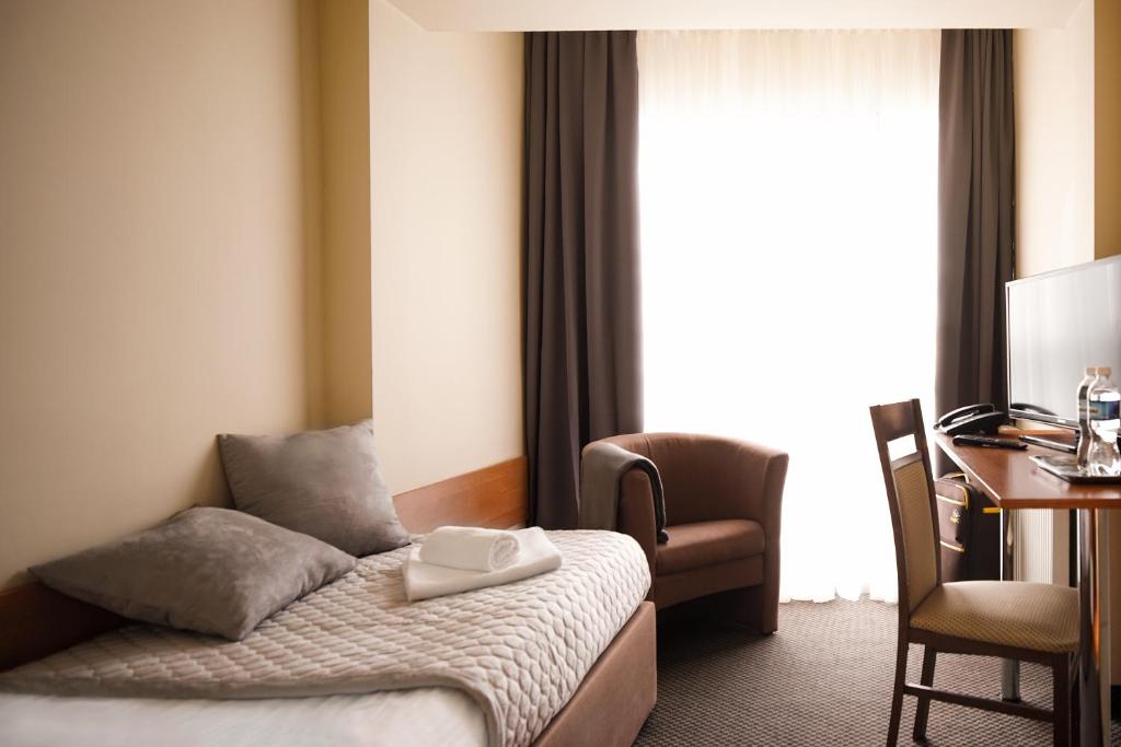 卢布林鲁博林公寓式酒店的配有一张床、一张书桌和一扇窗户的酒店客房