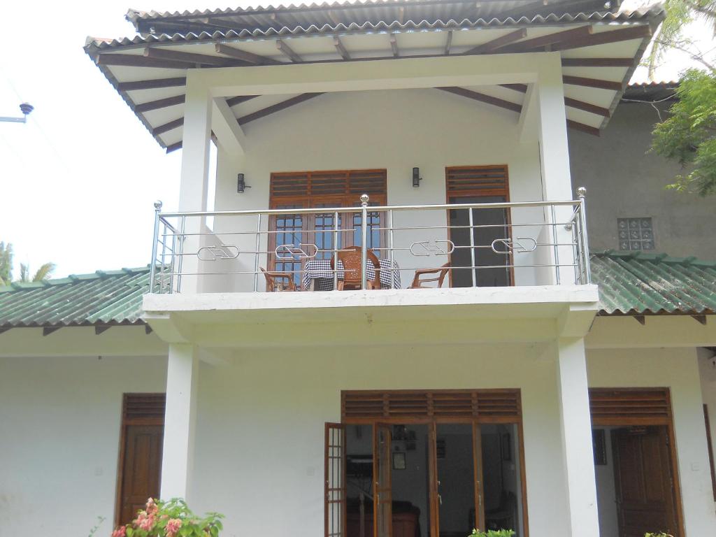 波隆纳鲁沃日落旅游之家民宿的房屋设有带椅子的阳台