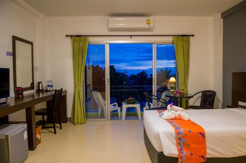 功孟海滩Z塔莱住宿加早餐旅馆的酒店客房设有一张床、一张书桌和一个阳台。