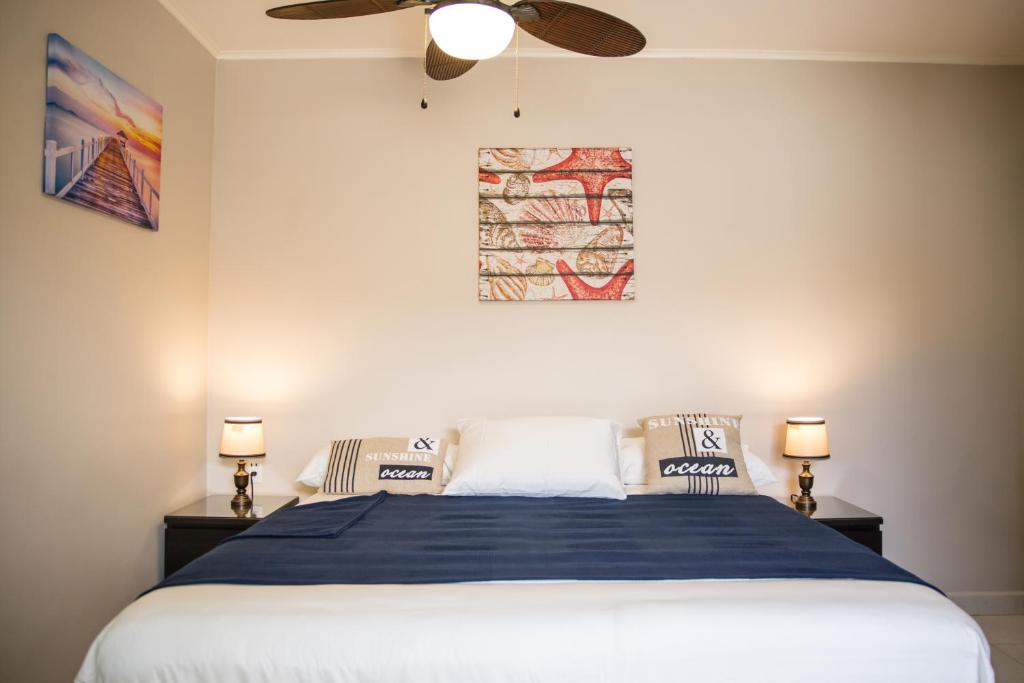 威廉斯塔德The Pier Beach Inn & Suites的一间卧室配有一张床和吊扇