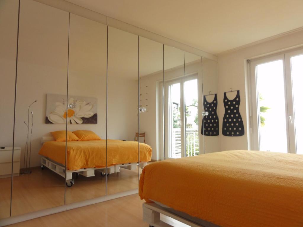 洛迦诺科里纳公寓式酒店的一间卧室配有两张床和镜子