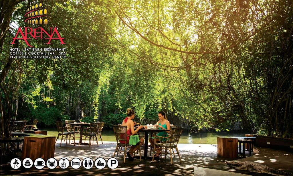 贝鲁沃勒阿瑞娜酒店的两个人坐在树下的桌子上