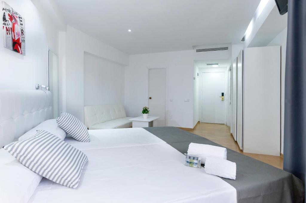 马德里Boutique Urban Madrid Génova的白色卧室配有一张带枕头的大白色床