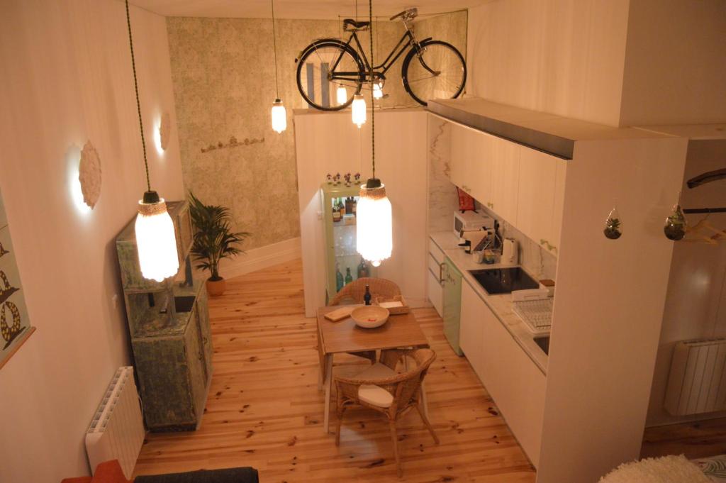 波尔图Oporto Old In New的厨房配有桌子,自行车悬挂在天花板上