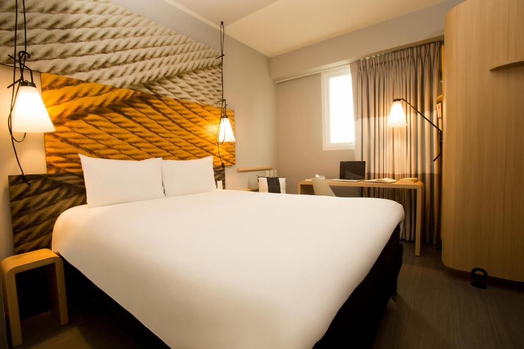 利马利马瑞度托米拉弗洛雷斯宜必思酒店的酒店客房设有一张白色大床和一张书桌