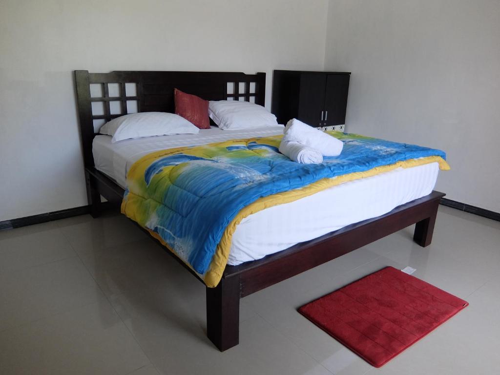 蓝梦岛韦迪彭杜克宾馆的一间带两张床的卧室和红色地毯