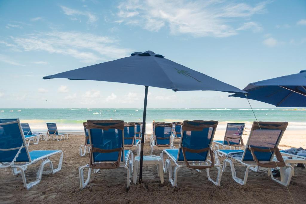 圣胡安OCEAN VIEW DELUXE SUITE: PVT. BEACH & POOL的海滩上的一组椅子和一把遮阳伞