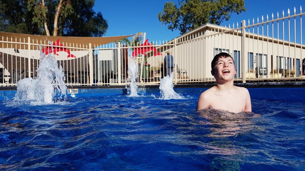 奥古斯塔港奥古斯塔西区康福特茵酒店的年轻人在带喷泉的游泳池里