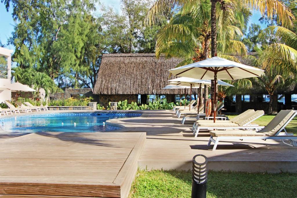 潘托皮芒荣幸别墅酒店的一个带躺椅和遮阳伞的游泳池