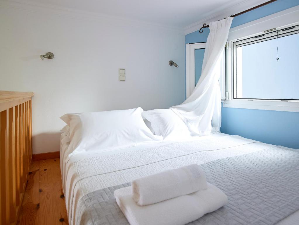 阿波罗尼亚Garifalakis House的卧室配有白色的床和窗户