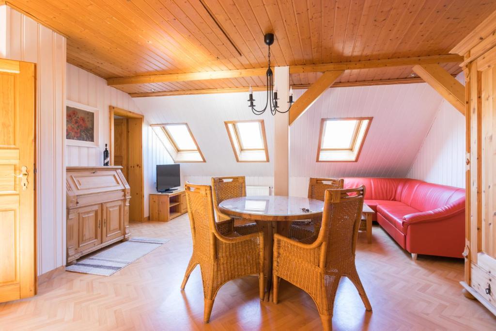 耶拿Apartments Ilmtal-Jena的一间带桌子和红色沙发的用餐室