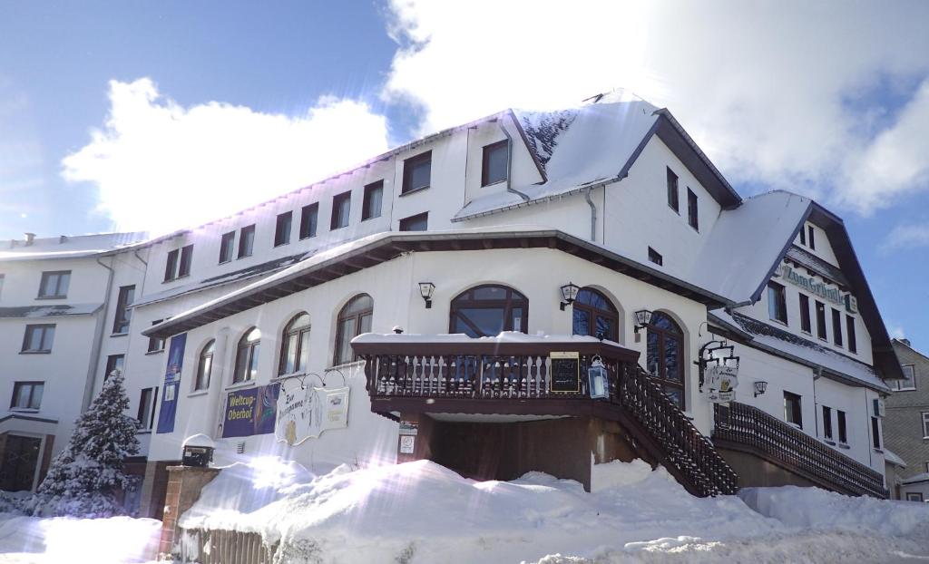 奥伯霍夫尊格瑞昂德尔酒店的一座白色的大建筑,在雪中设有阳台