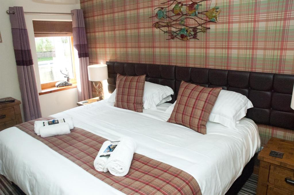 卡布里奇Strathspey Cottage的一间卧室配有一张大床和毛巾