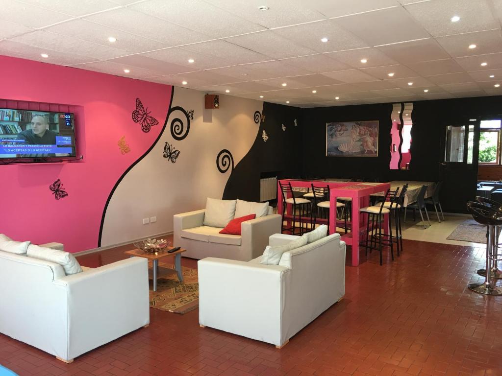 圣卡洛斯-德巴里洛切Italia Inn Hostel的客厅配有白色家具和粉红色的墙壁